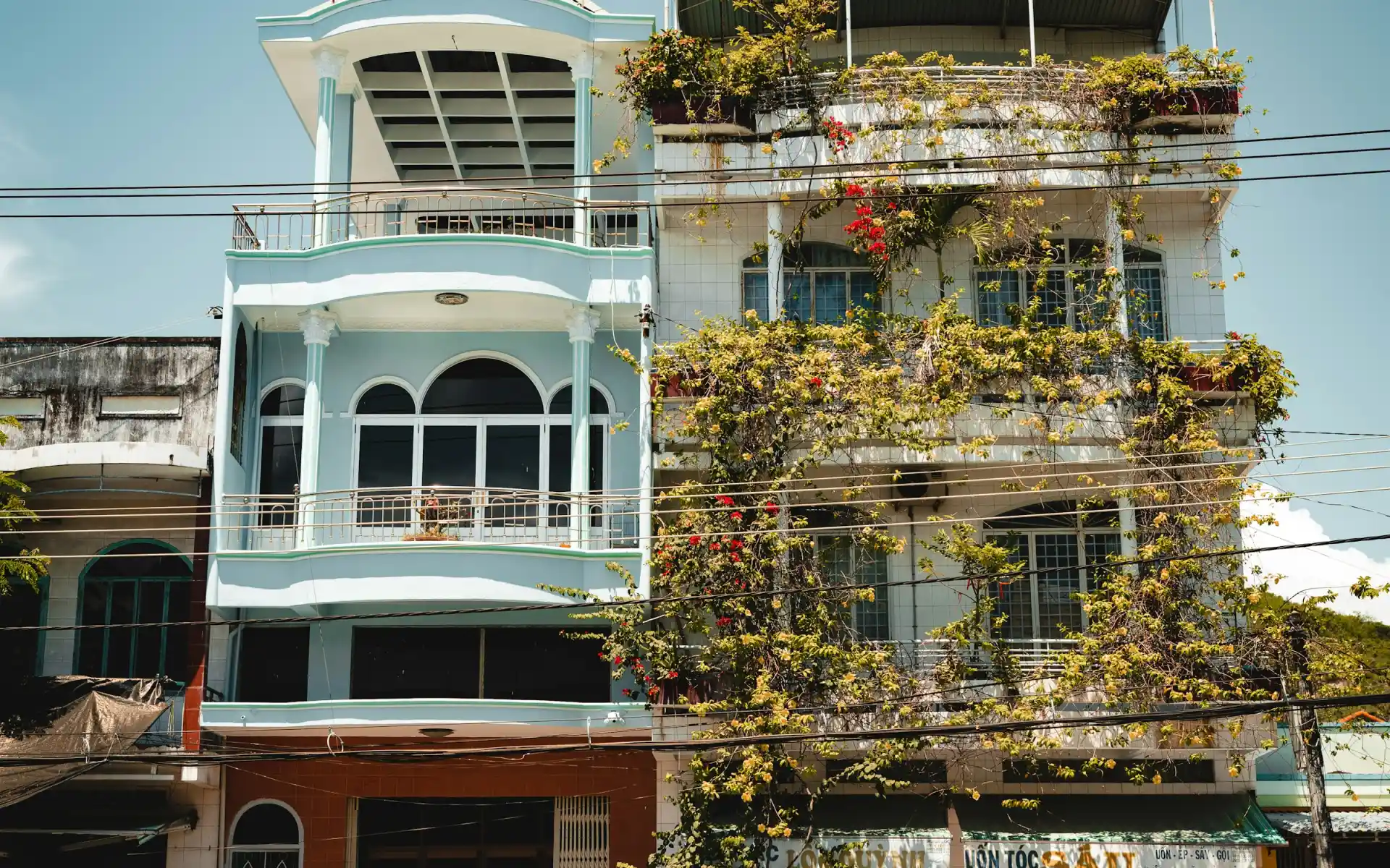 Mặt tiền nhà nghỉ 5 tầng ban ngày, biển hiệu Hạt Tiêu trên cửa kính, xe máy đỗ gọn trước cửa