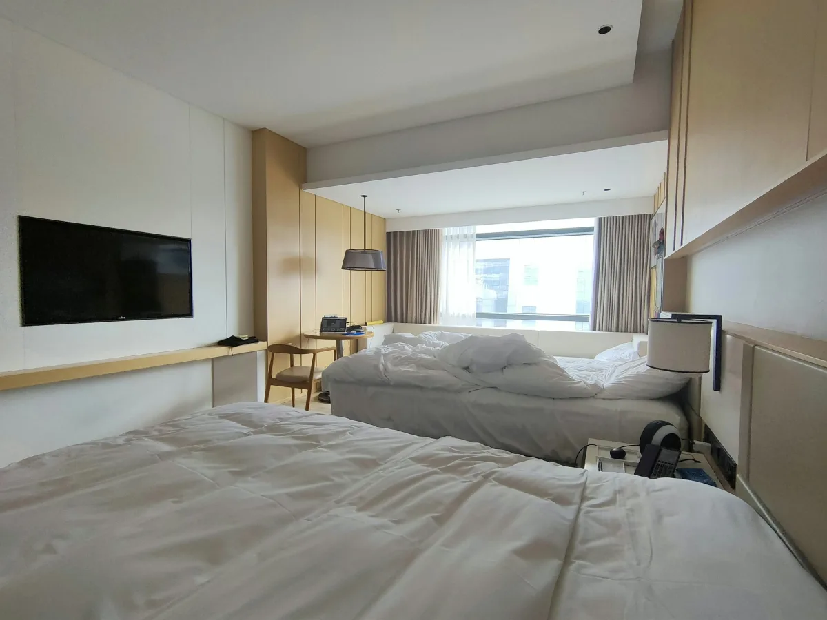 Góc phòng có ghế dài và bàn nhỏ, vali đặt gọn bên tường