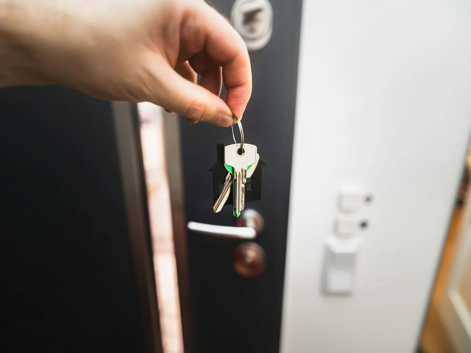 Quầy lễ tân gọn gàng, bàn tay nhân viên đưa chìa khóa thẻ từ qua mặt quầy